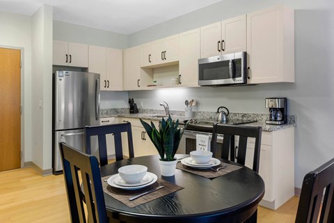 A kitchen with a table set for two.